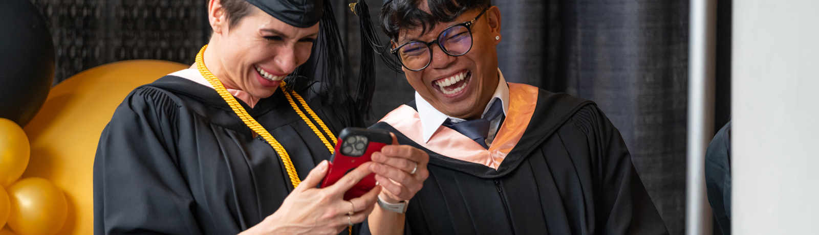 students laughing while looking at phone