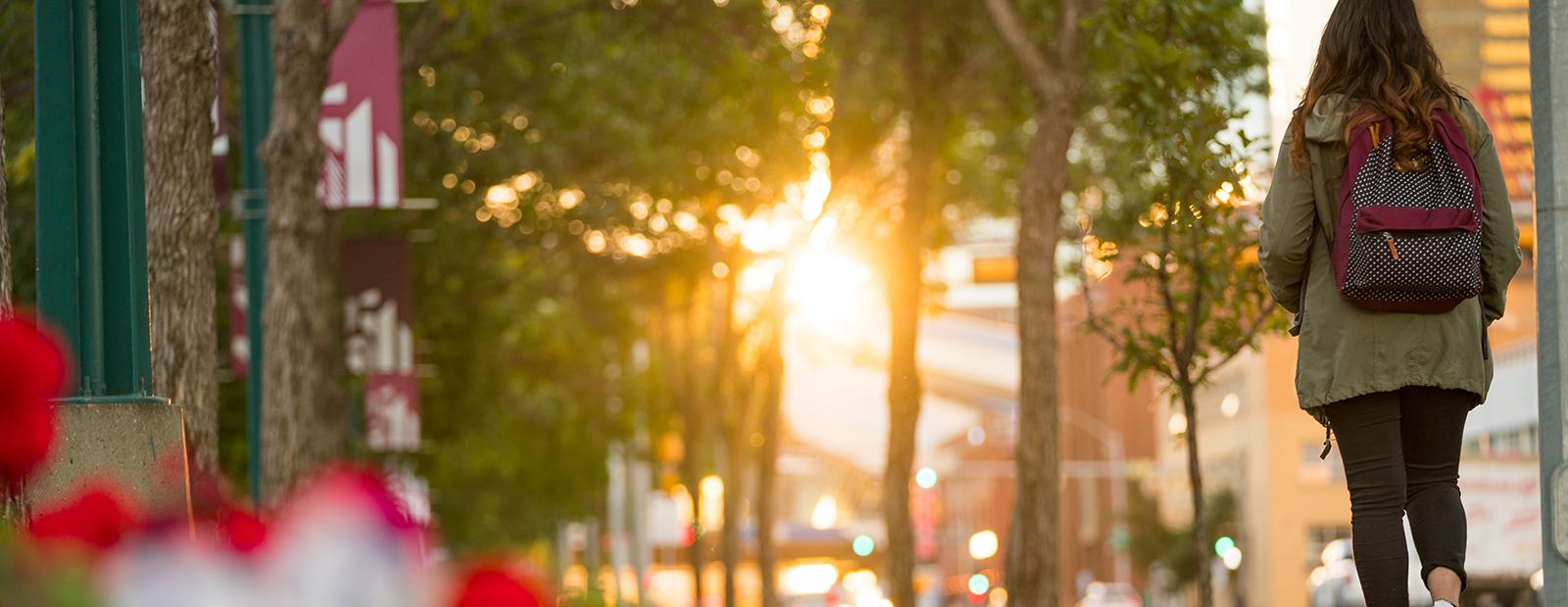 A young person walking toward the rising sun.