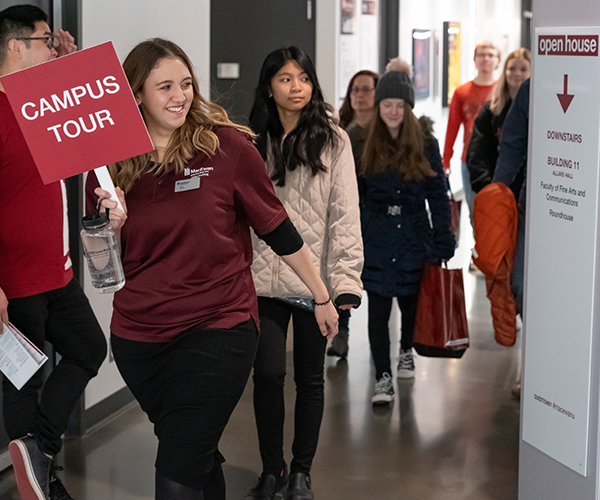 girl holding campus tours sign